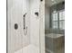 Modern shower with matte black fixtures, marble-like tiles, and glass door at 12707 Green Heron Way, Odessa, FL 33556