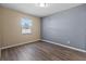 Bedroom featuring neutral paint, new floors, and a well-lit window at 14734 11Th St, Dade City, FL 33523