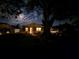 Charming single-story home with a well-lit entrance, offering a welcoming ambiance under the night sky at 14734 11Th St, Dade City, FL 33523