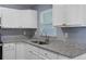 Kitchen features a stainless steel sink, granite counters, and white cabinets at 14734 11Th St, Dade City, FL 33523