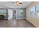 Bright living room with wood-look floors, two windows, and neutral wall paint at 14734 11Th St, Dade City, FL 33523