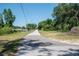 View of a quiet street, lined with green trees and utility poles at 14734 11Th St, Dade City, FL 33523