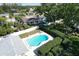 Aerial view of the backyard featuring a turquoise kidney-shaped pool with a lush green privacy hedge at 1535 Nursery Rd # 107, Clearwater, FL 33756