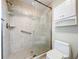 This bathroom features a tiled shower with glass door, safety bar and white fixtures at 1535 Nursery Rd # 107, Clearwater, FL 33756