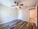 Bedroom with wood-look floors and a ceiling fan connects to a bathroom with tiled shower and toilet at 1535 Nursery Rd # 107, Clearwater, FL 33756