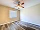 Bedroom with wood-style floors, ceiling fan, and a window offering natural light at 1535 Nursery Rd # 107, Clearwater, FL 33756