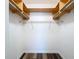 An empty walk-in closet featuring custom wood shelving and laminate floors at 1535 Nursery Rd # 107, Clearwater, FL 33756