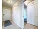 Neutral-toned hallway with tile floor features a mat at the front door and white doors and trim at 1535 Nursery Rd # 107, Clearwater, FL 33756