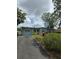 Charming single-story home with a driveway, lush lawn, and colorful flowers, creating curb appeal at 1607 Stevensons Dr, Clearwater, FL 33755