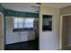 White kitchen cabinets with dark countertops and pineapple wallpaper at 1607 Stevensons Dr, Clearwater, FL 33755