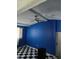 Room with black and white floors, bold blue wall, and ceiling fan at 1607 Stevensons Dr, Clearwater, FL 33755