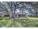 Large fenced-in yard and screened-in porch with trees and grass at 16501 Sandhill Crane Dr, Spring Hill, FL 34610