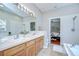 Bathroom featuring double sinks, wood cabinetry, and a separate shower and tub at 16501 Sandhill Crane Dr, Spring Hill, FL 34610