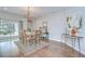 Dining room featuring wood floors, a decorative chandelier, and access to an outdoor patio at 16501 Sandhill Crane Dr, Spring Hill, FL 34610