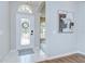 Bright entryway featuring a decorative glass door and neutral tile flooring, and an arched entry to other rooms at 16501 Sandhill Crane Dr, Spring Hill, FL 34610