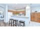 Well-lit kitchen with wood cabinets, breakfast bar with stools, and neutral countertops at 16501 Sandhill Crane Dr, Spring Hill, FL 34610