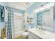 Charming bathroom with updated vanity, bright blue walls, and tiled shower at 17712 Long Ridge Rd, Tampa, FL 33647