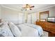 Cozy bedroom featuring hardwood floors, TV, and a ceiling fan at 17712 Long Ridge Rd, Tampa, FL 33647