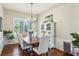 Elegant dining room with a wooden table, upholstered chairs, a chandelier, and plantation shutters at 17712 Long Ridge Rd, Tampa, FL 33647