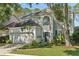 Charming two-story home features a well-manicured lawn, lush landscaping, and an attached two-car garage at 17712 Long Ridge Rd, Tampa, FL 33647