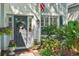 Inviting front entrance featuring a gray door adorned with a wreath, lush landscaping, and potted plants at 17712 Long Ridge Rd, Tampa, FL 33647