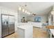 Bright kitchen showcasing stainless steel appliances, white cabinetry, and an island, seamlessly connecting to the living area at 17712 Long Ridge Rd, Tampa, FL 33647