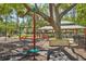 Community playground with a merry-go-round, picnic tables and green space at 17712 Long Ridge Rd, Tampa, FL 33647