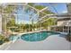 Relaxing pool and spa area with screened enclosure, cozy seating, and garden views at 17712 Long Ridge Rd, Tampa, FL 33647
