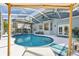 Stunning screened-in pool with a spa, surrounded by a cozy lounge area and manicured landscaping at 17712 Long Ridge Rd, Tampa, FL 33647