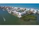 Waterfront condo complex featuring a community pool, boat docks, tennis courts, lush greenery and open water views at 19451 Gulf Blvd # 506, Indian Shores, FL 33785