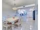Bright dining room featuring a white table, chairs, and access to the kitchen at 19451 Gulf Blvd # 506, Indian Shores, FL 33785