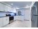 Kitchen featuring white cabinets, stainless steel appliances, a window, and tiled flooring at 19451 Gulf Blvd # 506, Indian Shores, FL 33785