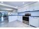 Bright kitchen featuring white cabinets, a stainless steel oven, and a dishwasher at 19451 Gulf Blvd # 506, Indian Shores, FL 33785