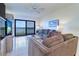 Living room with modern furniture, a ceiling fan, tile flooring, and access to balcony at 19451 Gulf Blvd # 506, Indian Shores, FL 33785