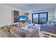 Cozy living room featuring tile floors, a large TV, and access to a balcony with a view at 19451 Gulf Blvd # 506, Indian Shores, FL 33785