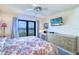 Well-lit main bedroom with TV, ceiling fan, and balcony access offering water views at 19451 Gulf Blvd # 506, Indian Shores, FL 33785