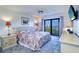 Bright bedroom with balcony access, featuring a plush bed and serene water views at 19451 Gulf Blvd # 506, Indian Shores, FL 33785