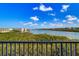 Scenic water view from the balcony on a bright day with beautiful green trees at 19451 Gulf Blvd # 506, Indian Shores, FL 33785