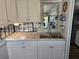 Bright kitchen featuring stainless steel sink, modern cabinets, countertops, and tiled backsplash at 2043 Ketch Cir, Palm Harbor, FL 34683