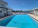 View of a refreshing community swimming pool with waterfront views and lounge chairs at 2043 Ketch Cir, Palm Harbor, FL 34683