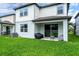 Backyard featuring lush green lawn, two-story house with covered patio for outdoor relaxation and entertainment at 20472 Monza Loop, Land O Lakes, FL 34638