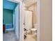 Hallway view with a bathroom showing modern fixtures, a shower, and neutral walls for a comfortable living space at 20472 Monza Loop, Land O Lakes, FL 34638
