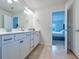 Bright bathroom with double vanity, white cabinets, granite countertops, and view to the bedroom at 20472 Monza Loop, Land O Lakes, FL 34638