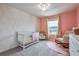 Well-decorated Bedroom with white crib, round pink rug, and gray walls at 20472 Monza Loop, Land O Lakes, FL 34638