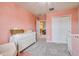 Bright pink Bedroom with white furniture, closet, and view into the hallway at 20472 Monza Loop, Land O Lakes, FL 34638