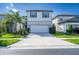Charming two-story home featuring a two-car garage, manicured lawn, and beautiful landscaping at 20472 Monza Loop, Land O Lakes, FL 34638