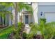 Inviting front entrance with lush landscaping leading to a covered porch and seating at 20472 Monza Loop, Land O Lakes, FL 34638