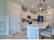Bright kitchen with stainless steel appliances, white cabinets, quartz countertops, and a kitchen island at 20472 Monza Loop, Land O Lakes, FL 34638