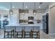 Modern kitchen with white cabinets, quartz countertops, stainless steel appliances, and island seating at 20472 Monza Loop, Land O Lakes, FL 34638