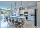 Bright kitchen with white cabinetry, stainless steel appliances, island with bar seating, and pendant lighting at 20472 Monza Loop, Land O Lakes, FL 34638